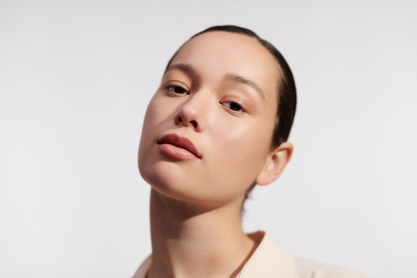 Rostro de mujer joven mostrando piel firme y radiante, tratamiento antiedad L'Occitane