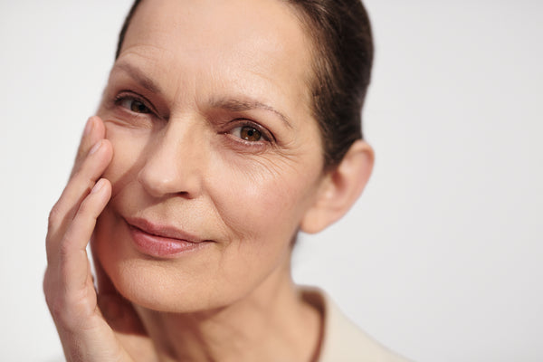 Mujer de piel madura sonriendo y mostrando reducción de arrugas, cuidado facial L'Occitane